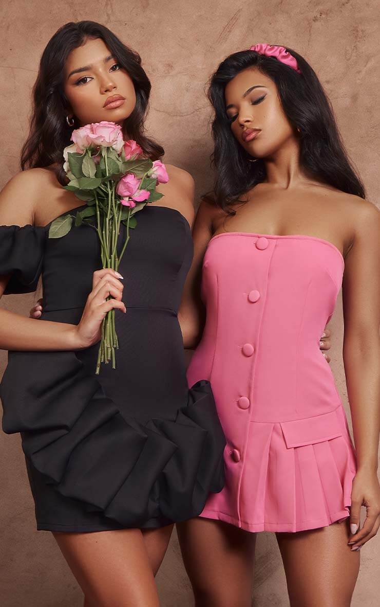 Two women, the first is wearing a black dress and the second is wearing a pink dress