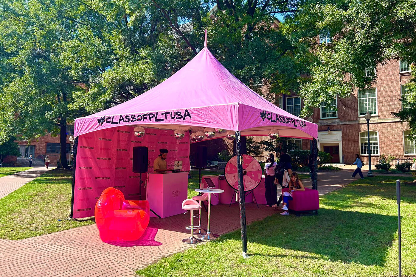 A pink PLT tent, with a DJ inside