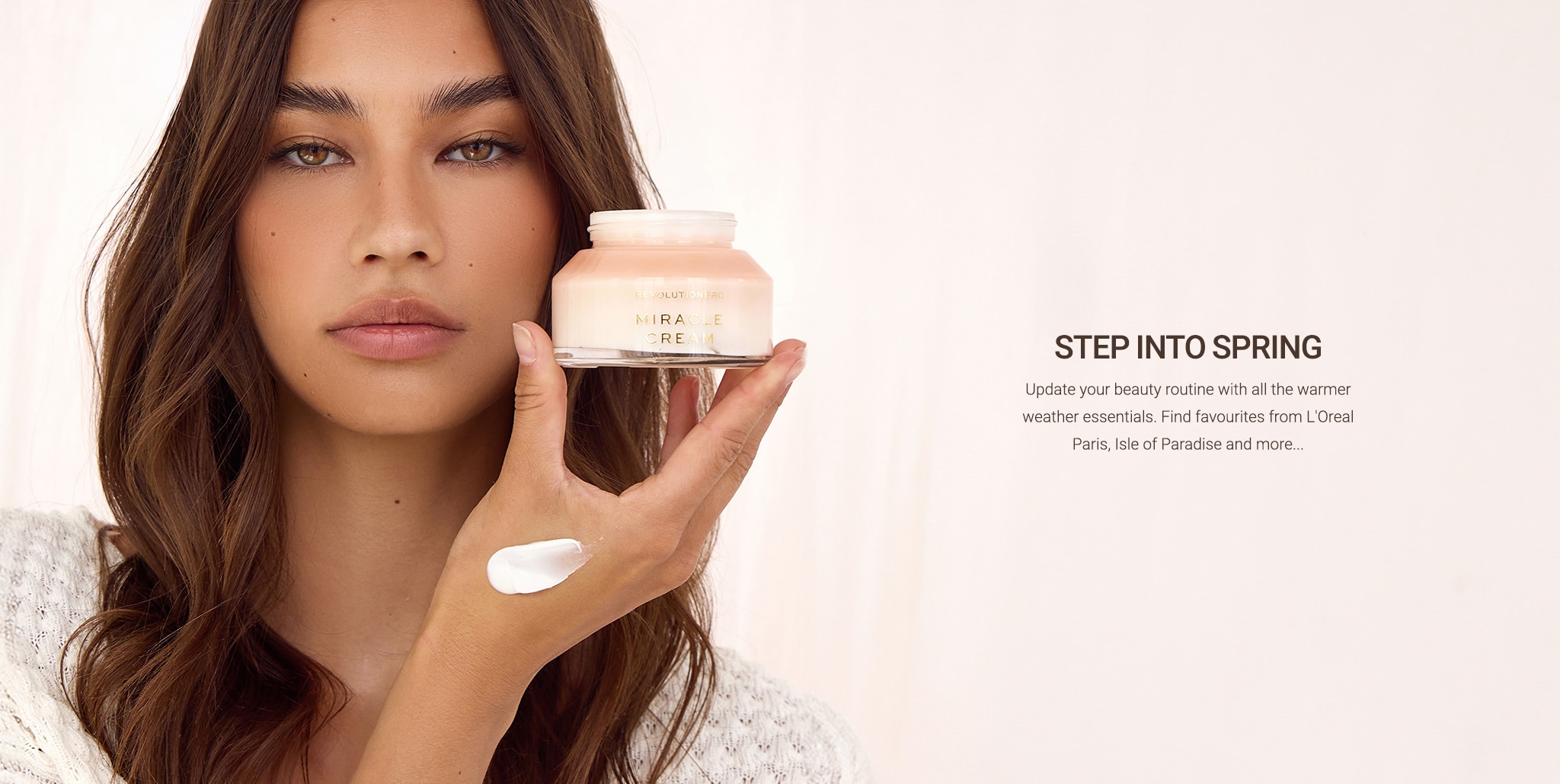 Female model on beige background holding moisturiser jar