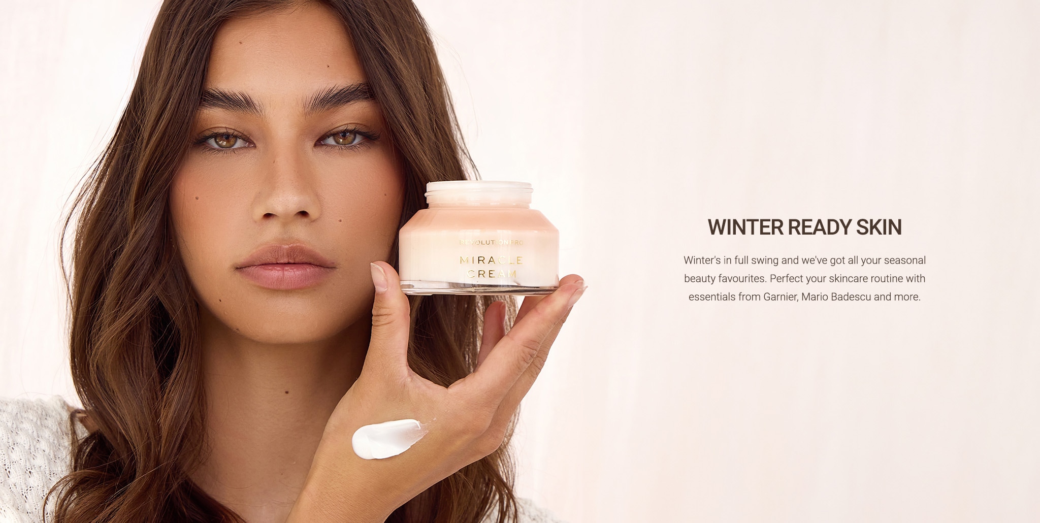 Female model on beige background holding moisturiser jar