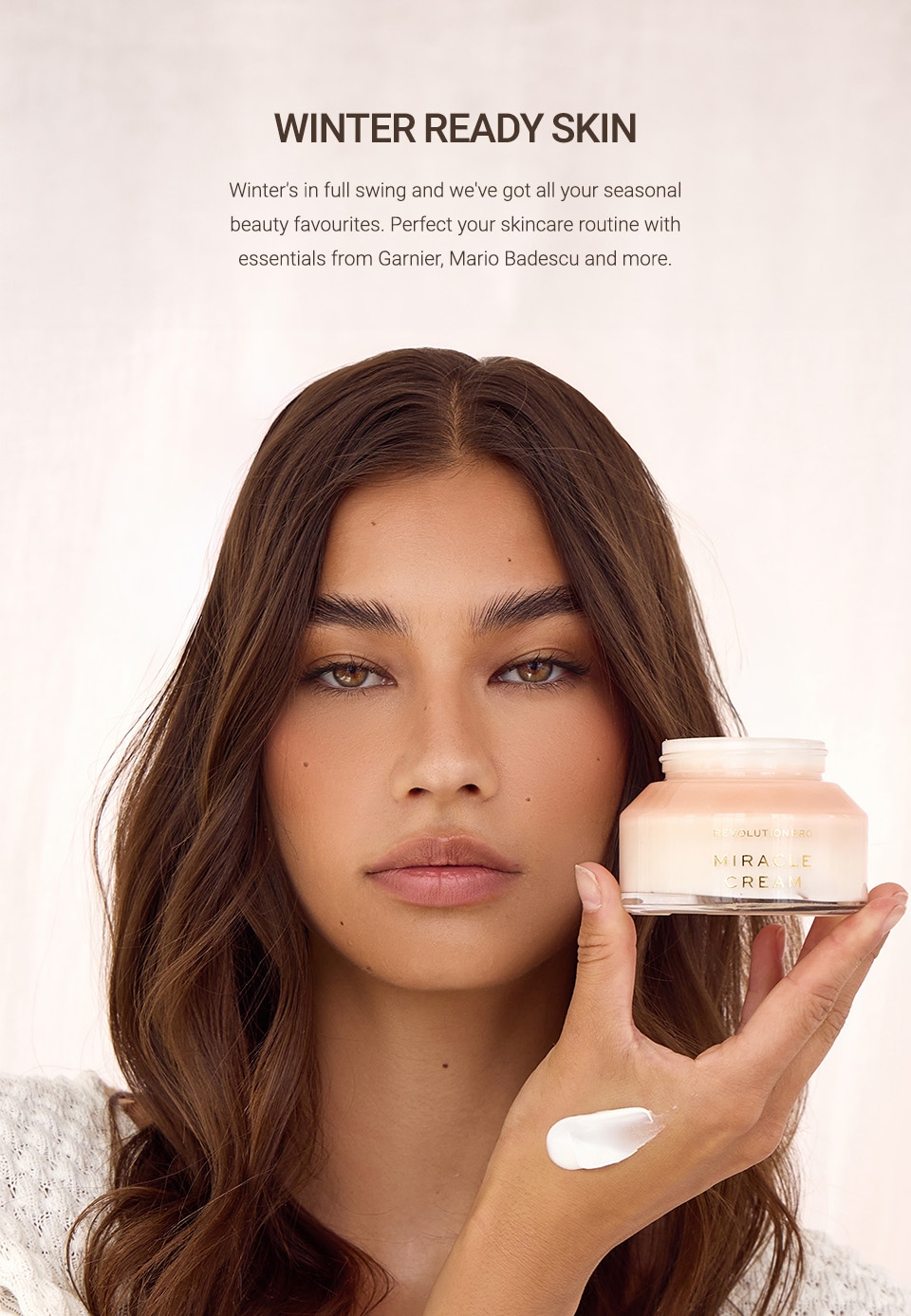 Female model on beige background holding moisturiser jar